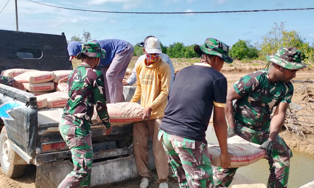 Anggota Satgas TMMD Ke-121 Kodim 0827/Sumenep Bersama Warga Menurunkan Material&nbsp;Semen
